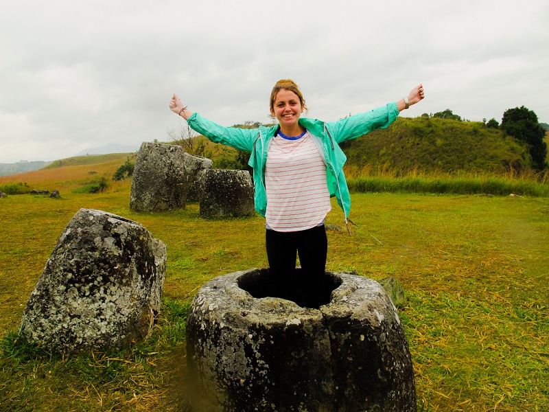 Tourist standing inside a giant stone jar