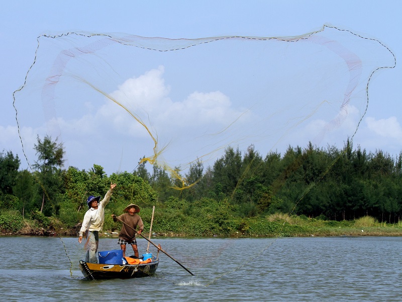 Fisherman throwing a fish net